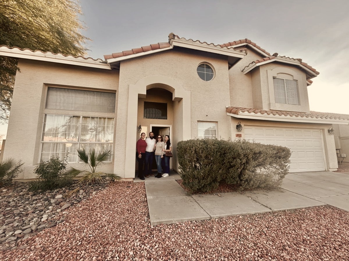 Holly with clients at the front door of their new Arizona home